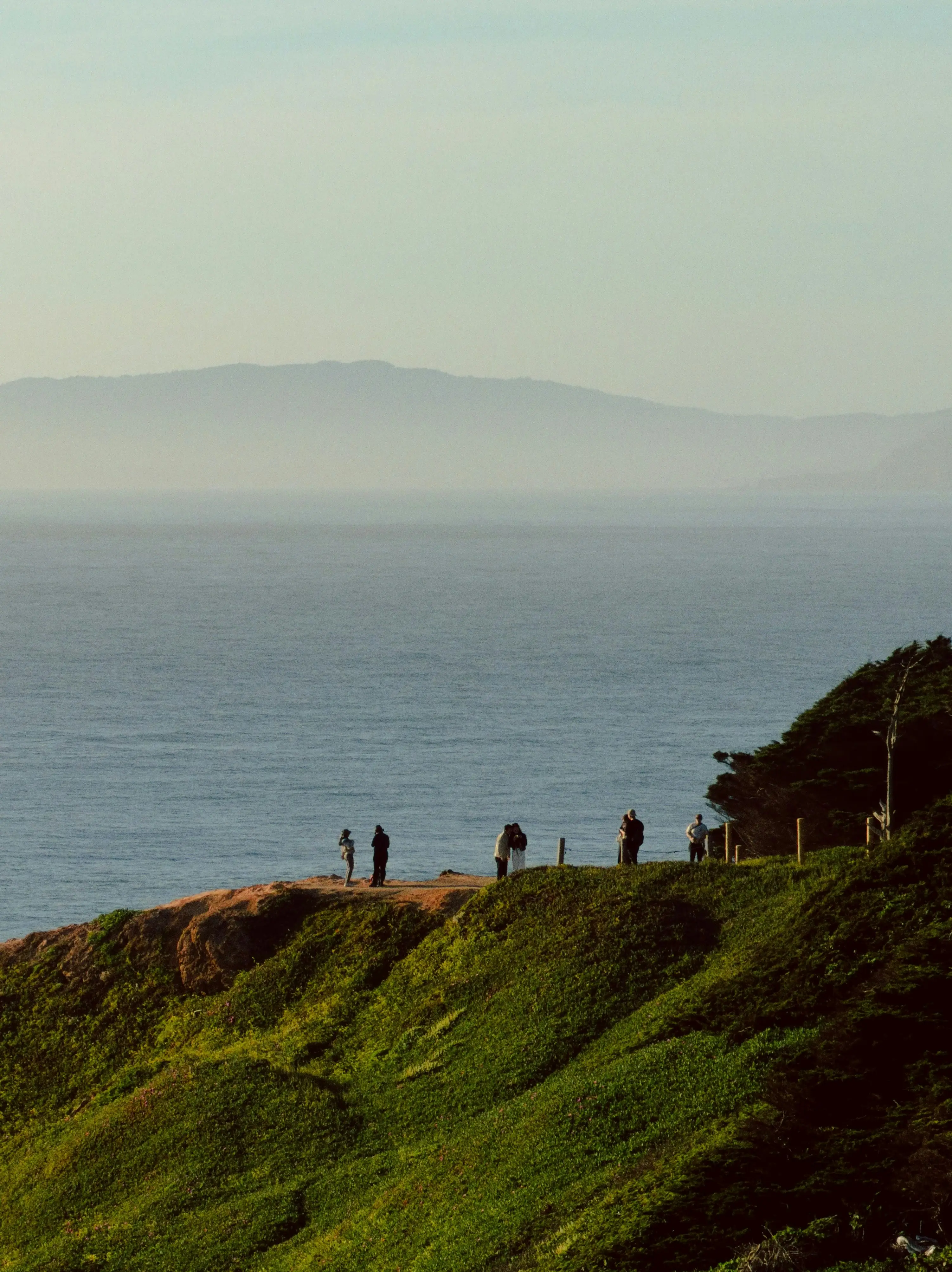 People on a coastal headland at dusk